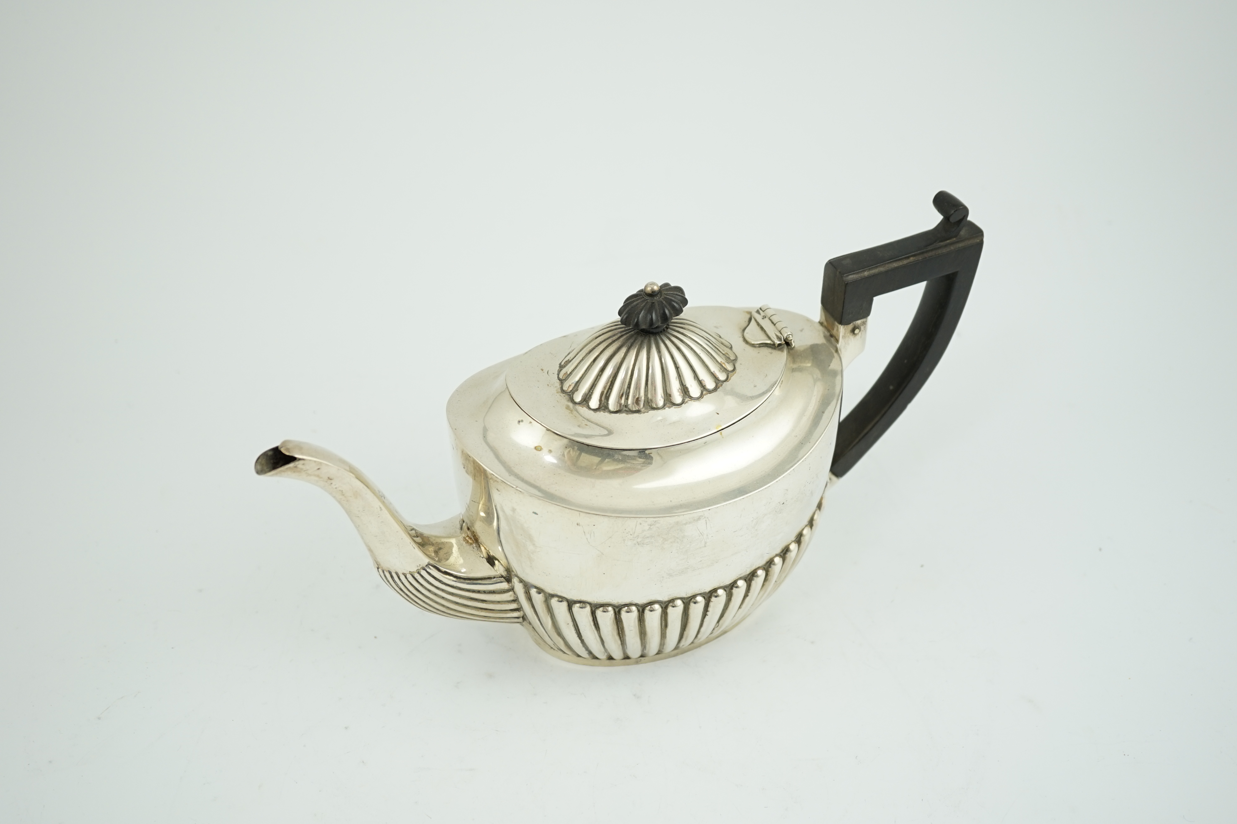 A late Victorian demi-fluted silver oval teapot, Nathan & Hayes, Chester, 1900, gross weight 17.1oz. Condition - fair.